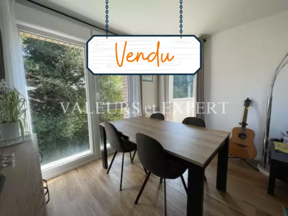 Grand séjour avec parquet clair, murs blancs et baie vitrée donnant sur l’extérieur.