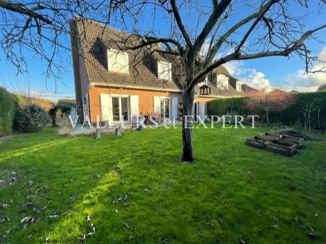 Façade moderne de la maison à Vendeville avec jardin verdoyant