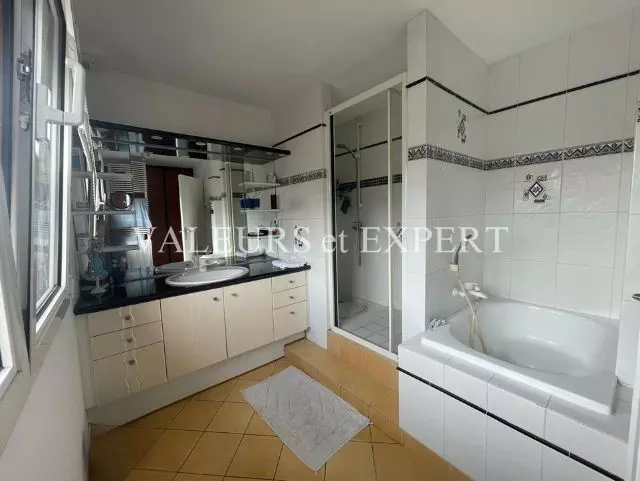 Salle de bain spacieuse avec baignoire, douche et double vasque à Templemars