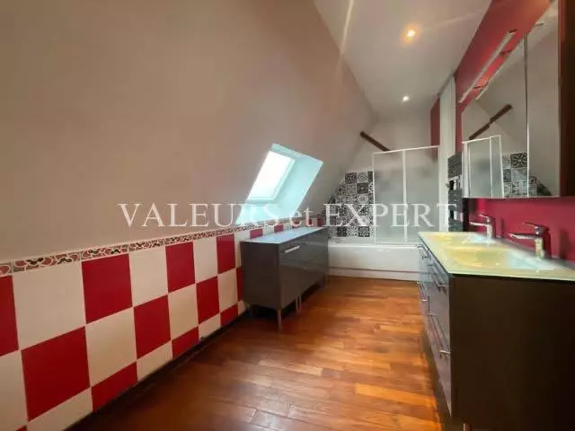 Salle de bains moderne avec double vasque et baignoire dans un appartement à Templemars.